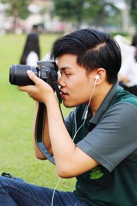 Side view of young man photographing