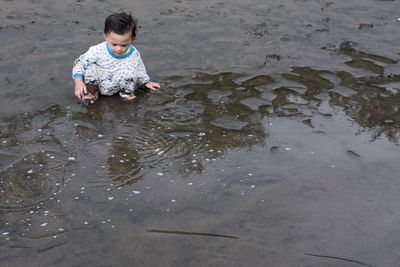 High angle view of boy sitting at beach