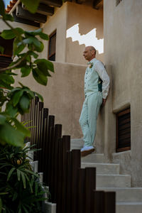 Side view of man standing against building