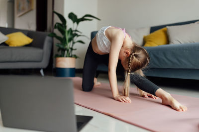 Full length of woman exercising at home