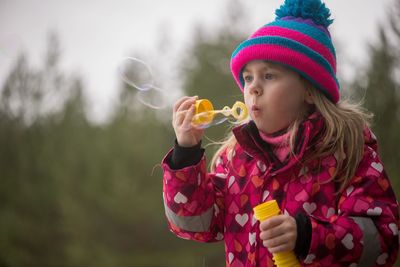 Close-up of girl blowing bubbles