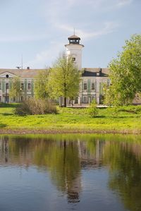 Buildings by lake against sky