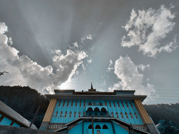 Low angle view of building against cloudy sky