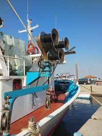 Sailboats moored at harbor against clear blue sky