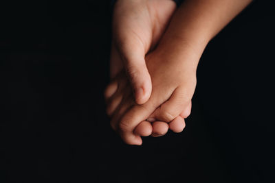 Cropped hand of person against black background