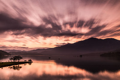 Scenic view of dramatic sky over lake during sunset