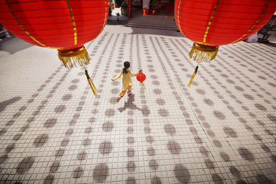 High angle view of girl running while holding chinese lantern