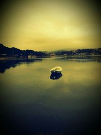 Reflection of clouds in sea at sunset