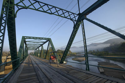 Footbridge over river against sky