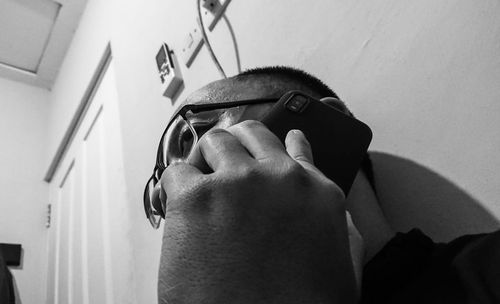 Close-up of man holding eyeglasses at home