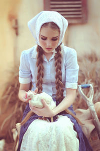 Full length of woman holding girl looking at camera