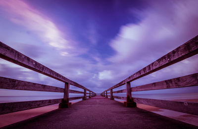 Bridge over calm sea against sky