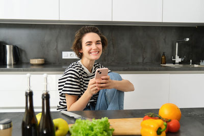 Portrait of young woman sitting at home