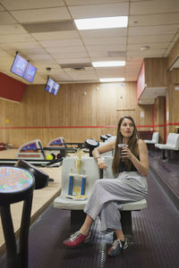 A young woman eating beside a trophy.