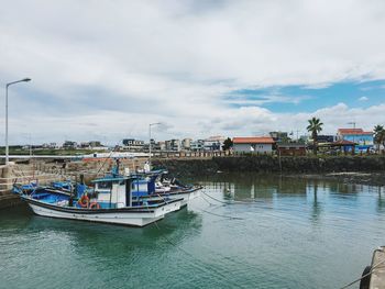 Boat moored at harbor against sky