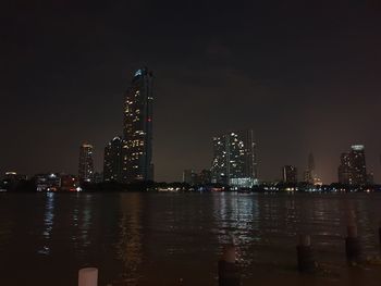 Illuminated buildings in city against sky at night