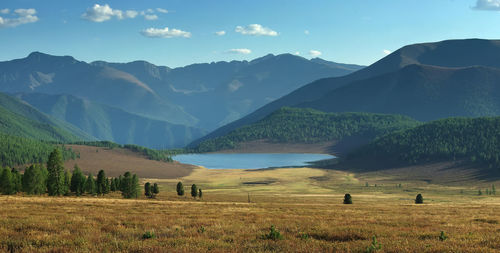 Scenic view of field and mountains against sky