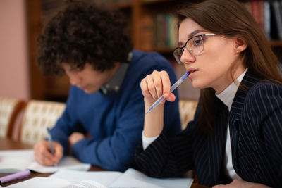 Thoughtful student holding pen during studies