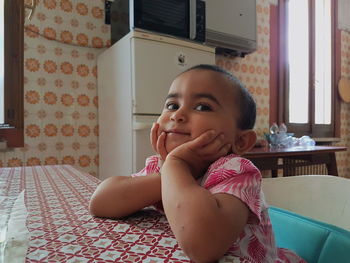 Portrait of cute baby girl sitting at home