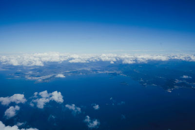 Aerial view of sea against blue sky