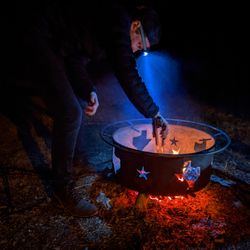 Man preparing food on fire at night