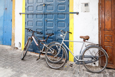 Bicycles parked on footpath against building