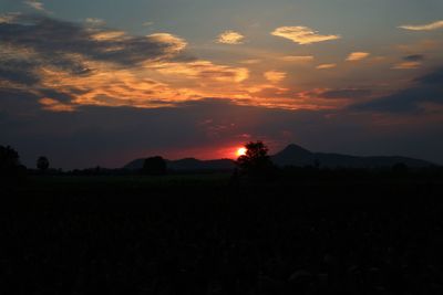 Scenic view of silhouette field against sky during sunset