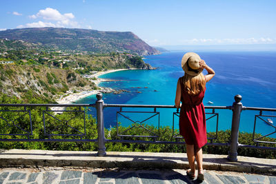 Panoramic view of young woman with hat in capo vaticano on the coast of the gods, calabria, italy.