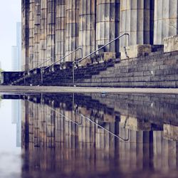 Bridge over river against buildings in city