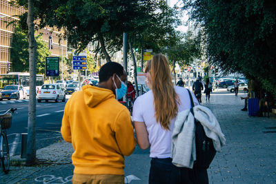 Rear view of women walking on street in city