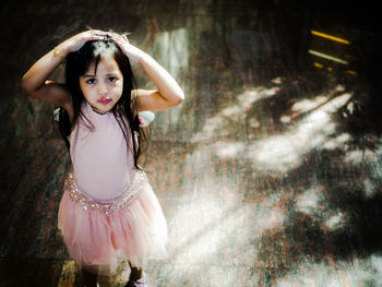 High angle portrait of girl standing on hardwood floor