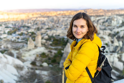 Woman traveler in bright yellow jacket at sunset in central turkey