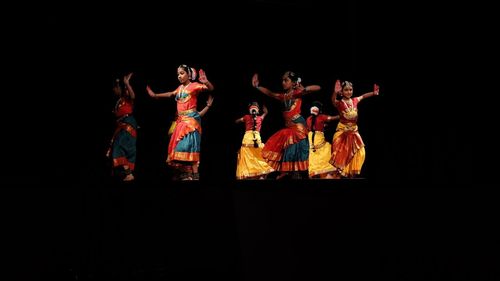 People dancing against black background