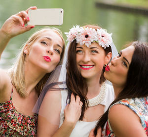 Happy bride with friends taking selfie