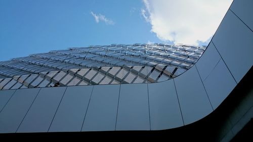 Low angle view of modern soccer stadium against sky