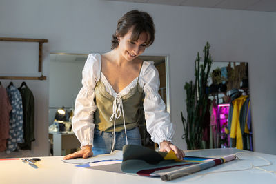 Young designer woman dressmaker work on new clothes collection in studio workshop. small business.