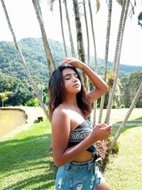 Portrait of beautiful young woman standing on land