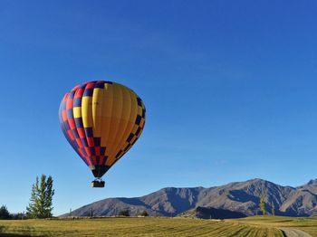 Hot air balloon flying against clear blue sky