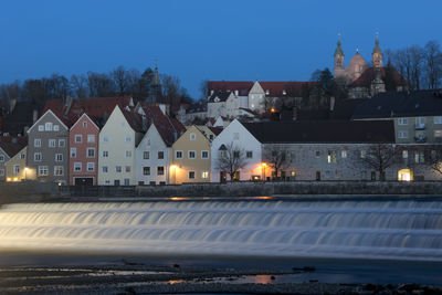 Illuminated buildings against sky at dusk