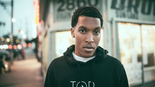 Portrait of young man standing in city