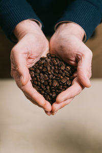 Close-up of hand holding coffee beans