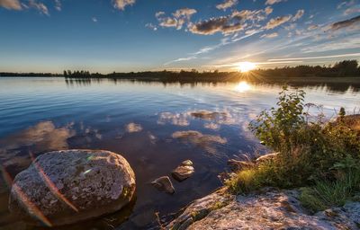 Scenic view of calm lake against sky during sunset