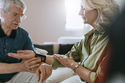 Senior couple taking blood pressure at home