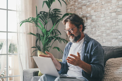 Smiling businessman talking on video call at home office