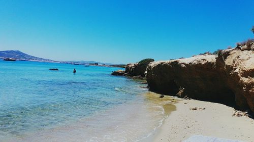 Scenic view of beach against clear blue sky