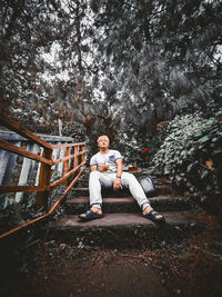 Portrait of young man sitting in forest