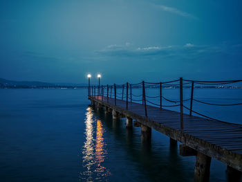 Pier over sea against sky at dusk