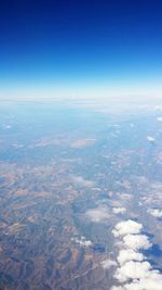 Aerial view of landscape against blue sky