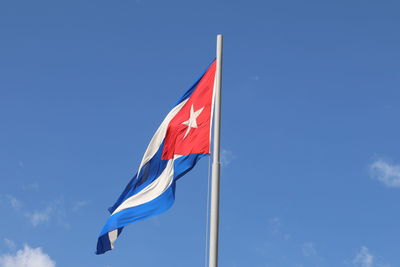 Low angle view of flag against blue sky