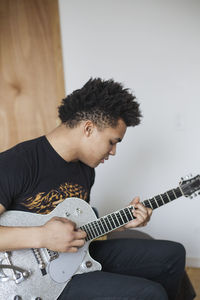 Young man playing an electric guitar